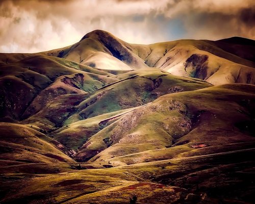 The iconic rolling hills of Bohol, covered in lush green, under a dramatic sky.